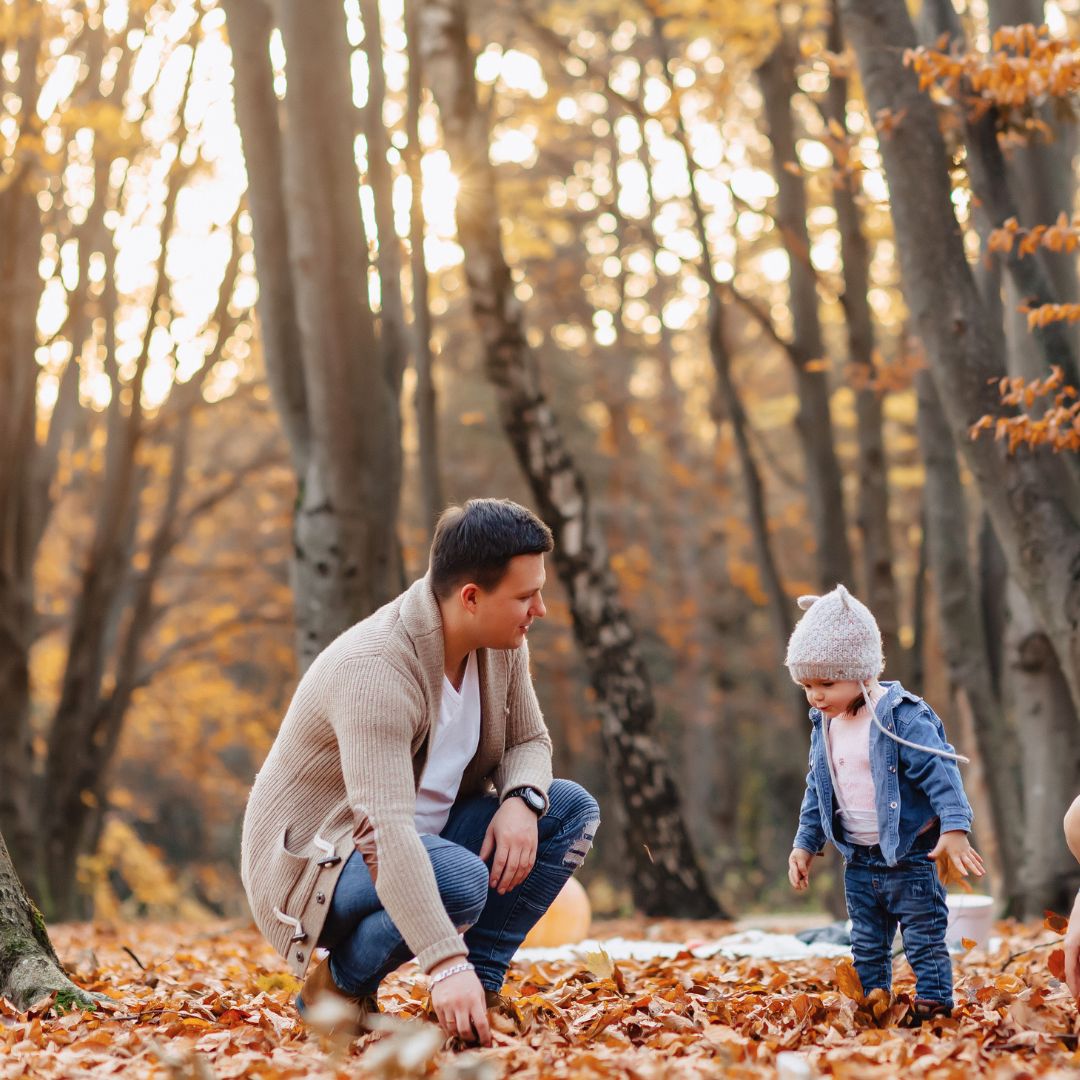Vader en kind buiten spelen in herfst