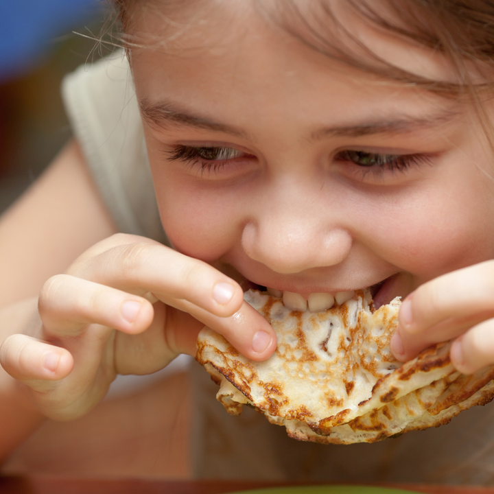 Kind eet pannenkoek
