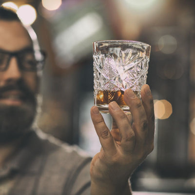 man kijkt naar glas rum