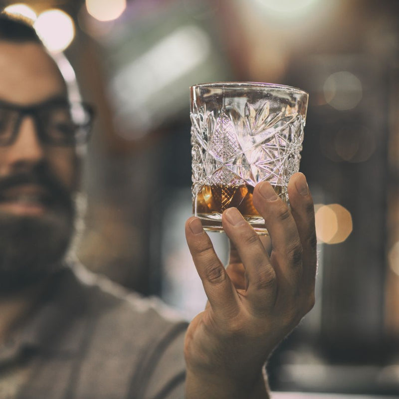 man kijkt naar glas rum